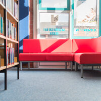Ein rotes Sofa in der Leseecke in der Stadtbücherei.