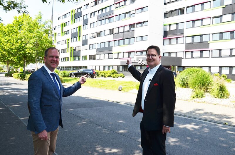 Bürgermeister Dirk Breuer und Unternehmensberater Guido Mumm stehen vor Gebäude in der Robert-Bosch-Straße.