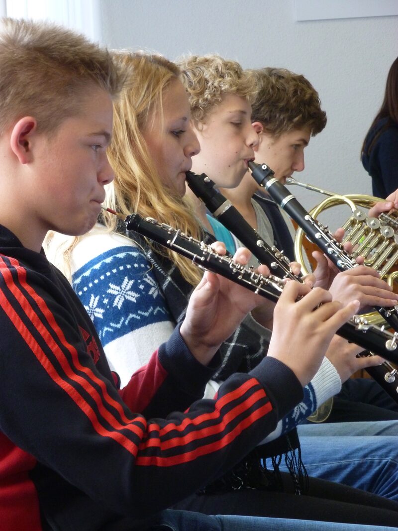 Schüler der Joseph-Metternich Musikschule sitzen in einer Reihe mit ihrem Instrument.