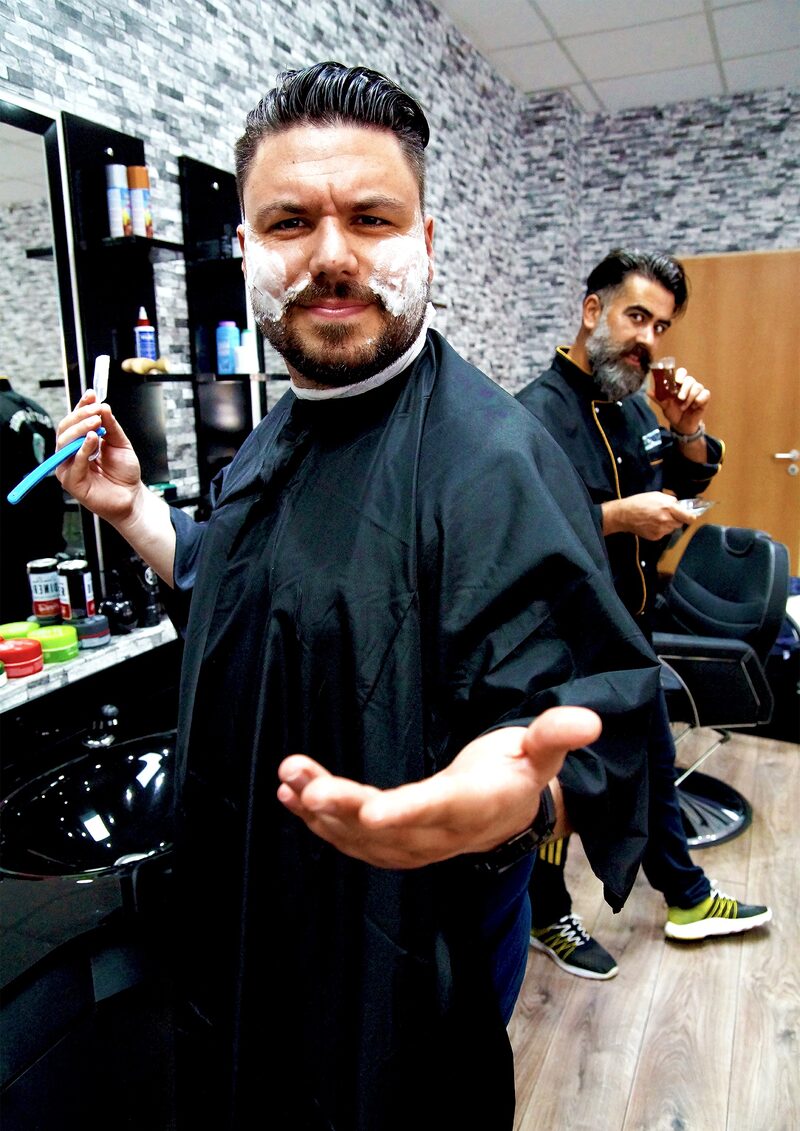 Sertac Mutlu steht in einem Friseuersalon.