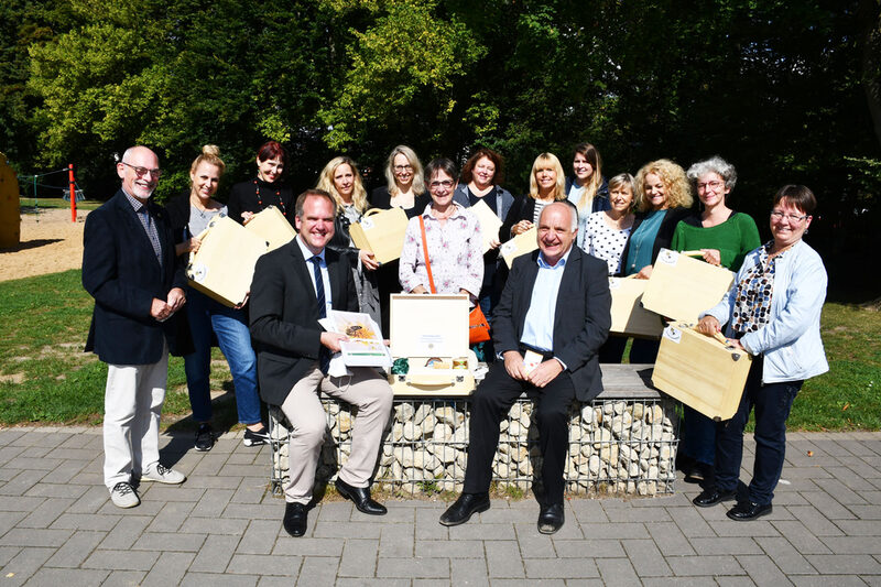 Bürgermeister Dirk Breuer und Rolf Meier (v.l. sitzend) präsentierten im Beisein aller Betreiligten die Koffer mit Informationen zum Schutz von Wildbienen.