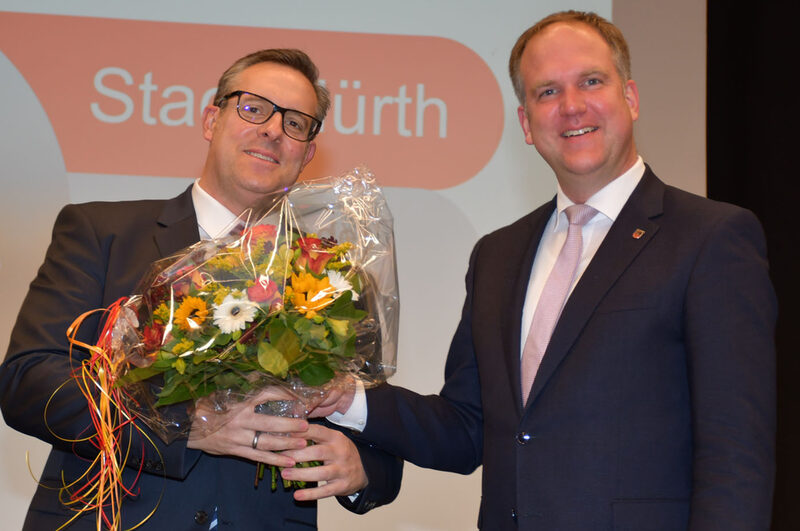 Bürgermeister Dirk Breuer (r.) gratulierte Jens Menzel mit einem Blumenstrauß.