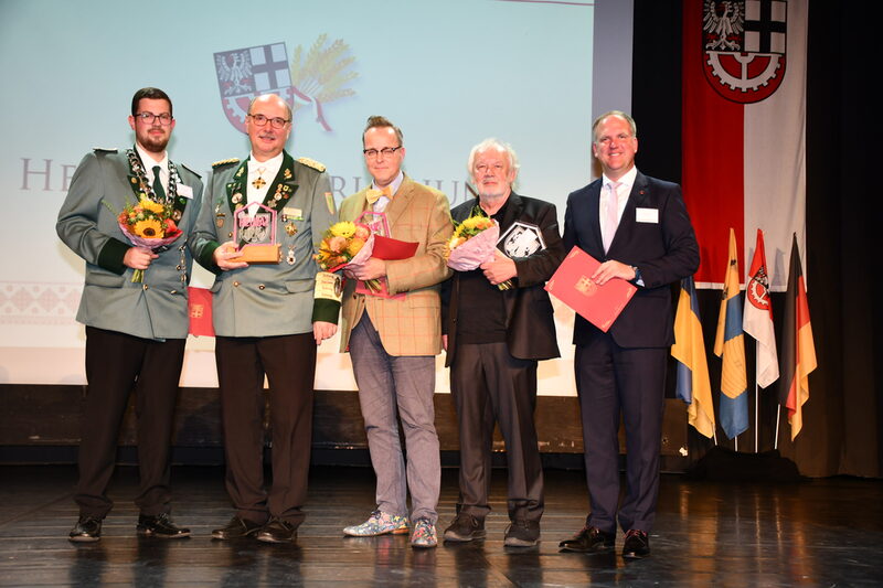 Auf der Bühne im Bürgerhaus nahmen (v.l.n.r.) Fabio Wagner, Peter Horst, Michael Schumacher und Alfons Domma den Heimatpreis entgegen, den Bürgermeister Dirk Breuer zuvor überreicht hatte.