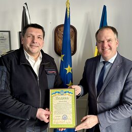 Bürgermeister Dirk Breuer (rechts) überreicht die Urkunde der ukrainischen Feuerwehr stellvertretend an Michael Mund, Leiter der Hürther Feuerwehr.