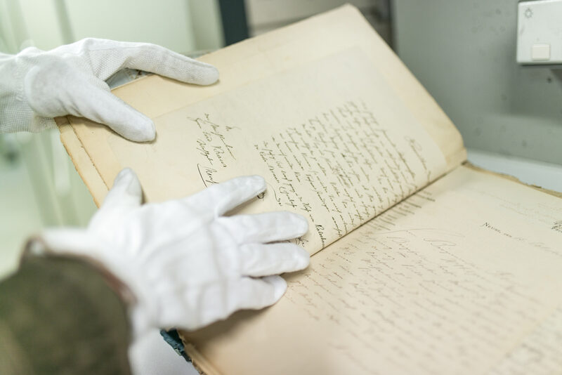 Stadtarchiv Sichtung eines alten Dokumentes mit Handschuhen
