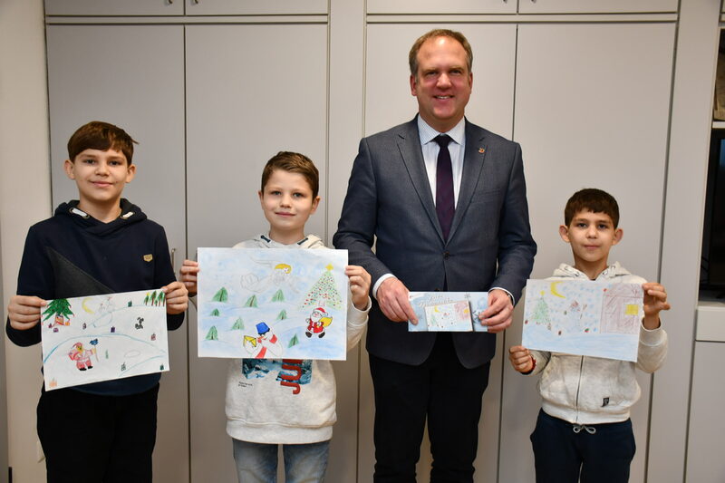 Maksym Kopaihorodskyi, Gleb Kolesnikov und Serhii Kopaihorodskyi (v.l.n.r.) präsentierten Bürgermeister Dirk Breuer ihre Zeichnungen. Foto: Pütz